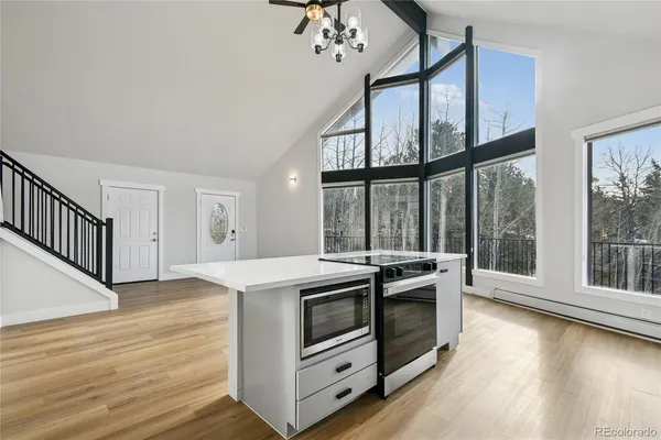 a kitchen with a stove and wooden floor