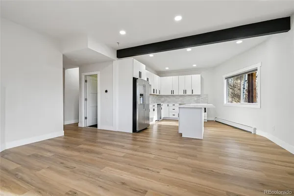 a large kitchen with stainless steel appliances a sink and a refrigerator