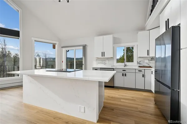 a kitchen with white cabinets and white appliances