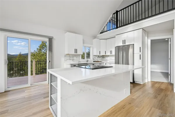 a kitchen with stainless steel appliances a kitchen island hardwood floor sink and stove