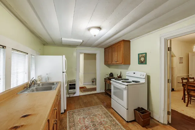 a kitchen with a stove a sink a refrigerator and cabinets