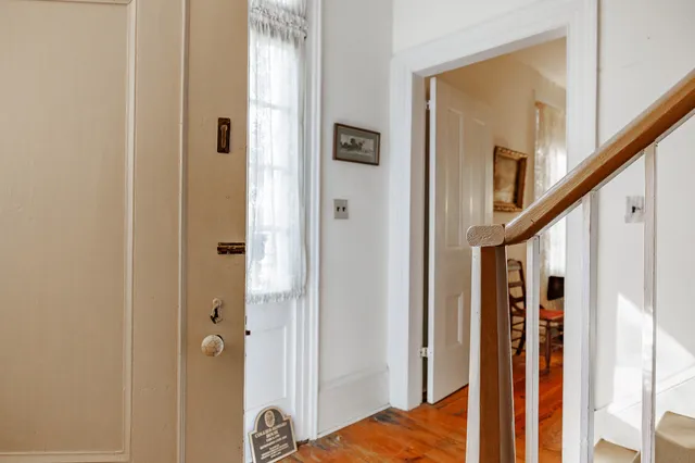a view of a hallway with wooden floor and entryway