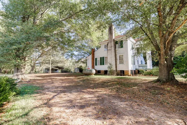a white house that has a tree in front of it