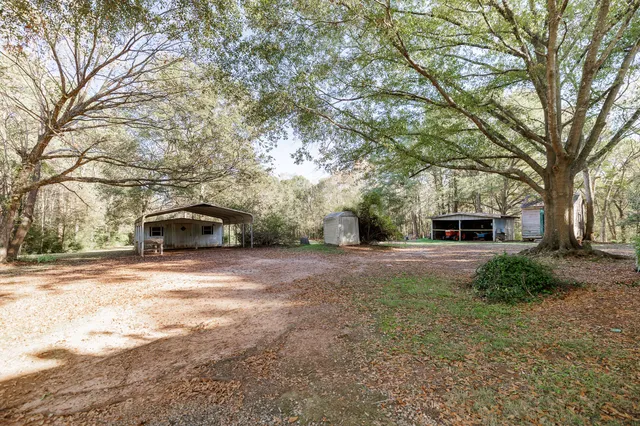a front view of a house with a yard and trees