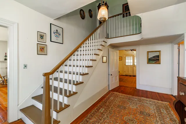 a view of staircase with white walls and frames on wall