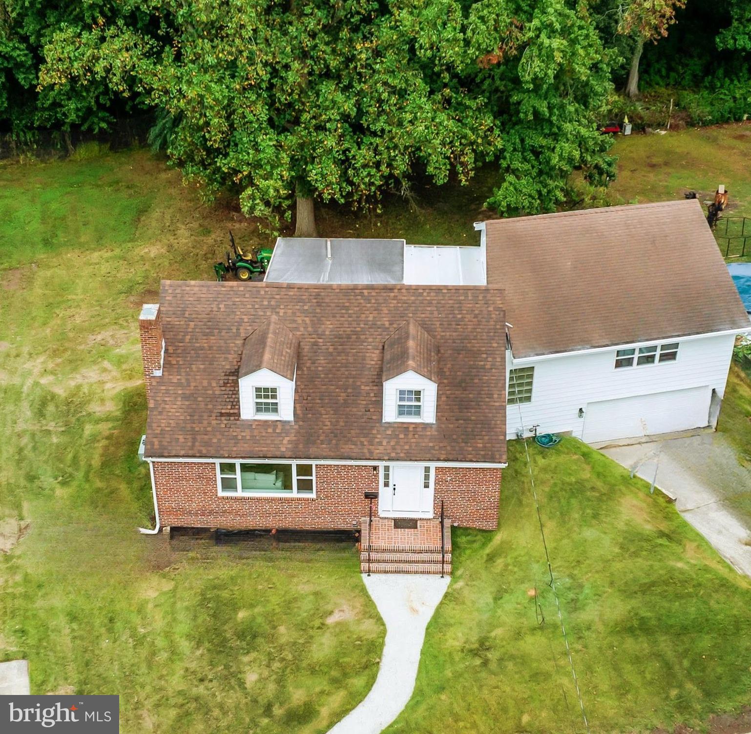 an aerial view of a house with swimming pool and a yard