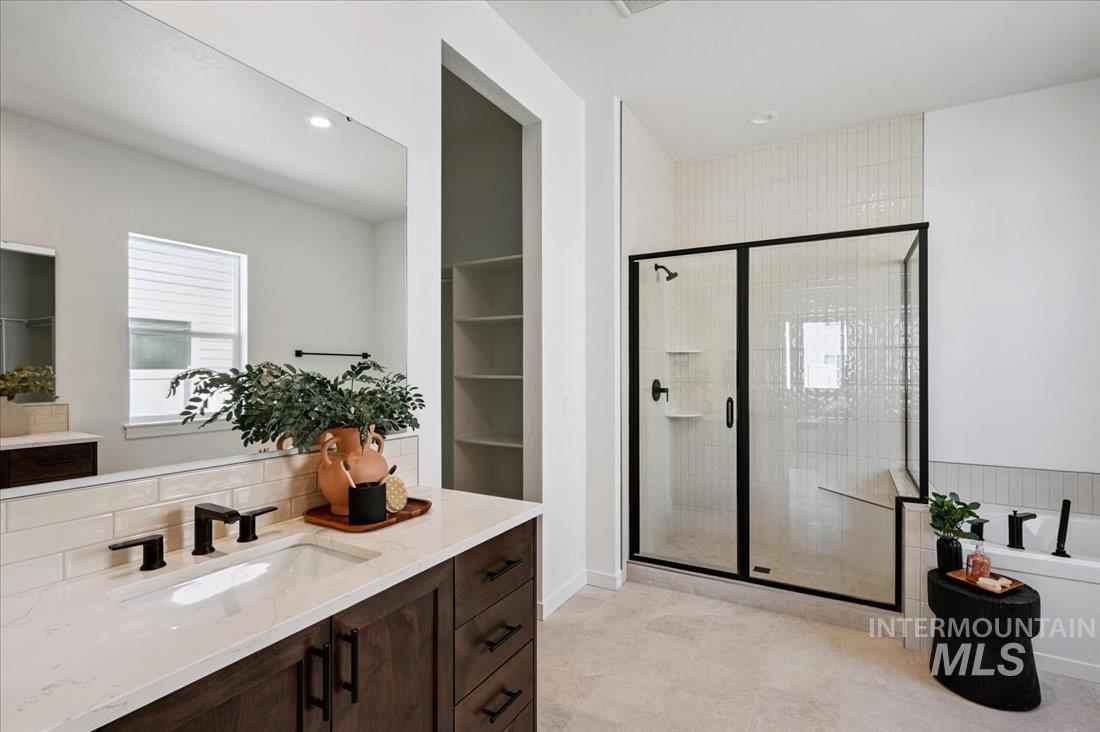1432 North Callander Way Star, ID 83669 - Photo 11 of 13 Modern bathroom featuring a dark wood-finish vanity with a white countertop and rectangular sink, black fixtures, a spacious walk-in shower with a black-framed glass enclosure, and a built-in bathtub