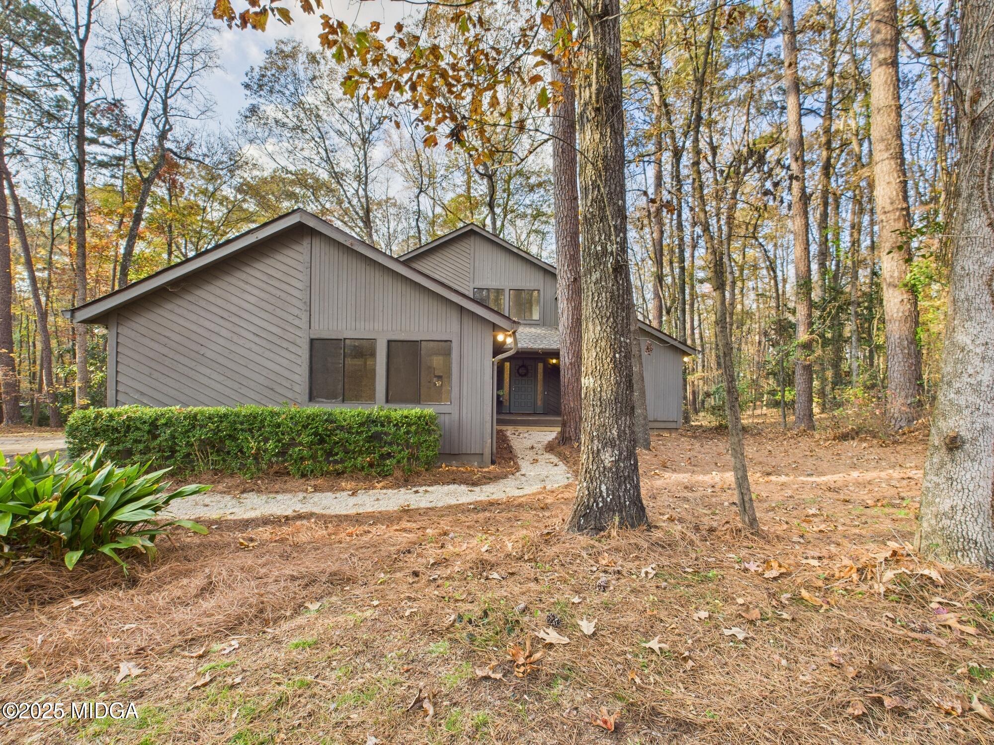 a view of a house with backyard and trees
