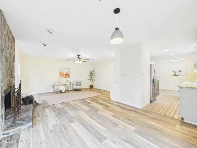 a view of a room with wooden floor and a ceiling fan