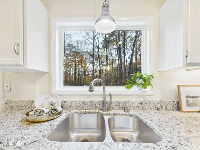a kitchen with a granite countertop sink a stove and a wooden floor