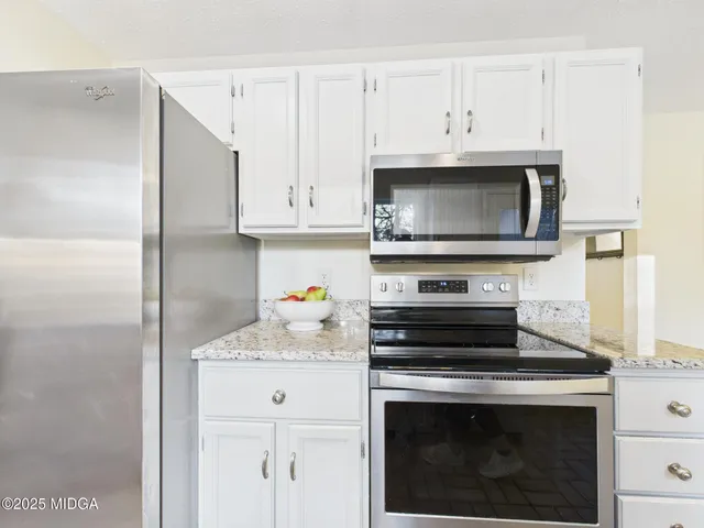 a kitchen with cabinets stainless steel appliances and a counter space