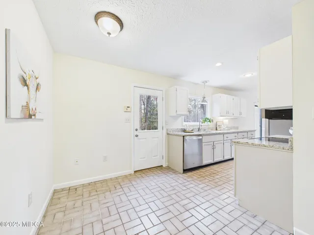 a kitchen with white cabinets and sink