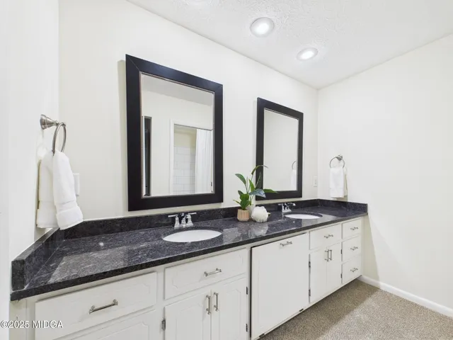 a bathroom with double sink and a mirror