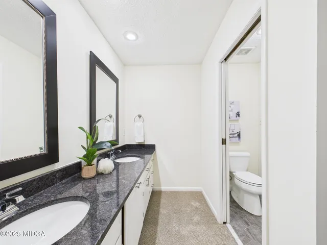 a bathroom with a granite countertop sink and a mirror