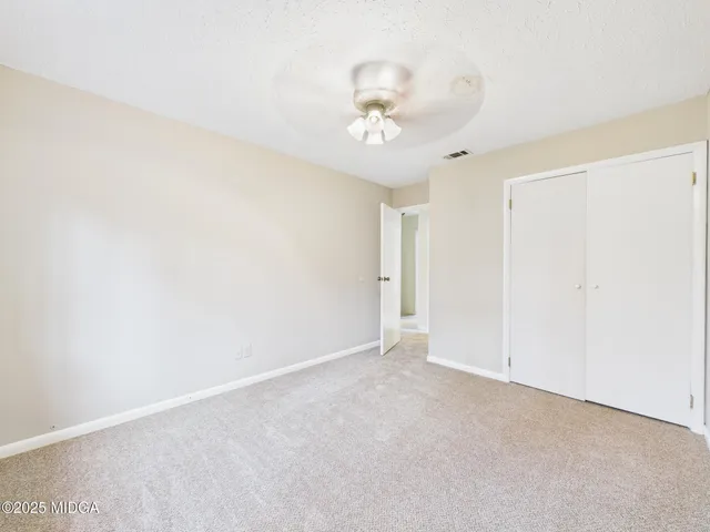an empty room with a ceiling fan and a window