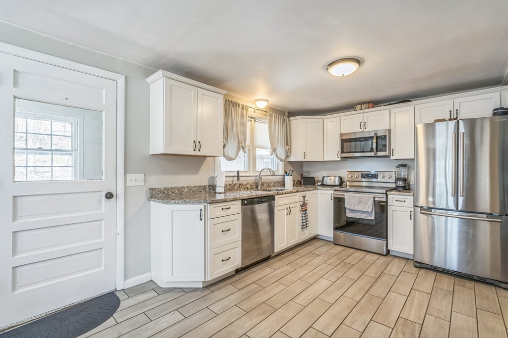 156 Andover Road Billerica, MA 01821 - Photo 4 of 22 a kitchen with granite countertop appliances cabinets and a sink