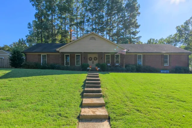 a front view of a house with a yard and trees