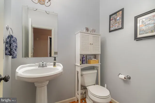 a bathroom with a toilet a sink and mirror