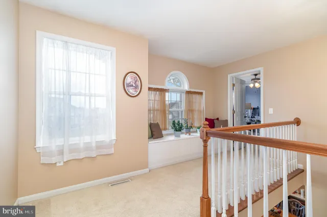 a view of a bedroom with wooden floor and windows