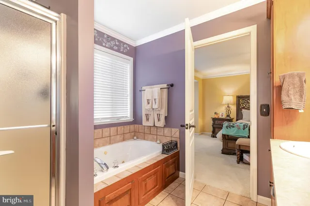 a bathroom with a tub a mirror and a shower