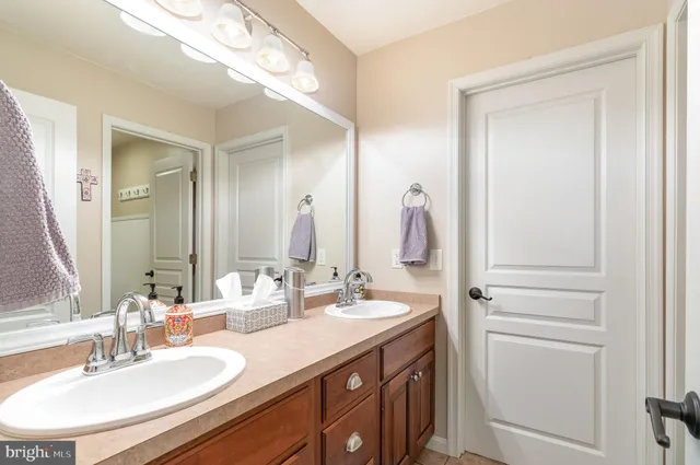 a bathroom with a double vanity sink and a mirror