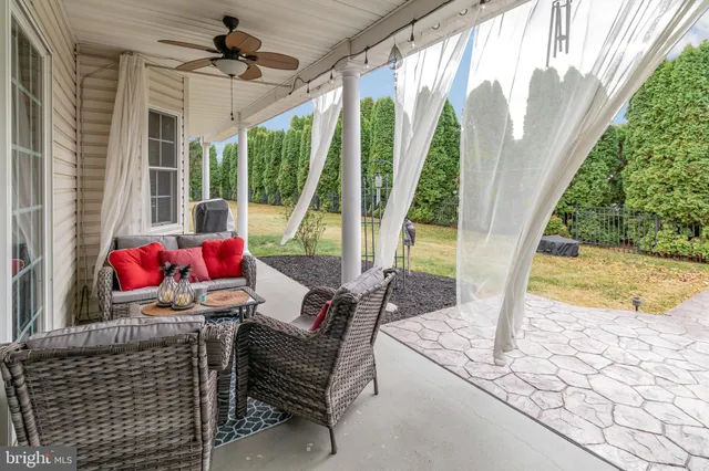 a living room with patio furniture and a floor to ceiling window