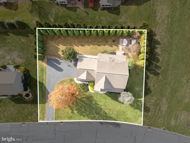 an aerial view of a house with a garden and lake view