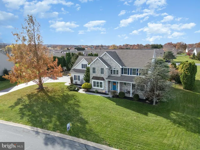 an aerial view of a city with lots of residential buildings ocean and mountain view in back