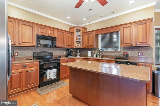a kitchen with stainless steel appliances granite countertop a stove sink microwave and window