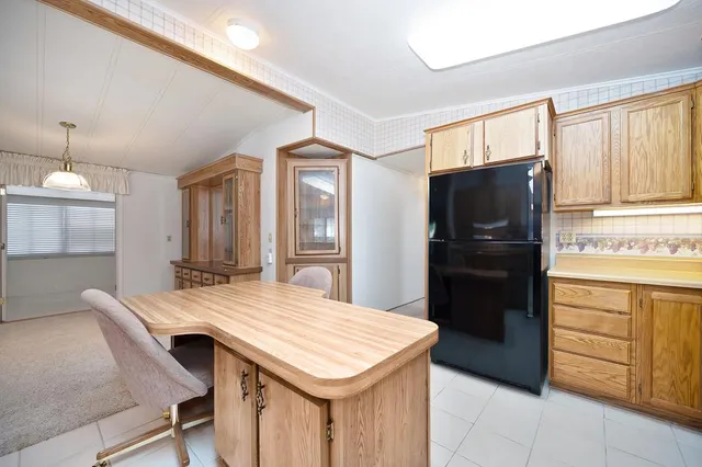 a kitchen with a table chairs refrigerator and microwave