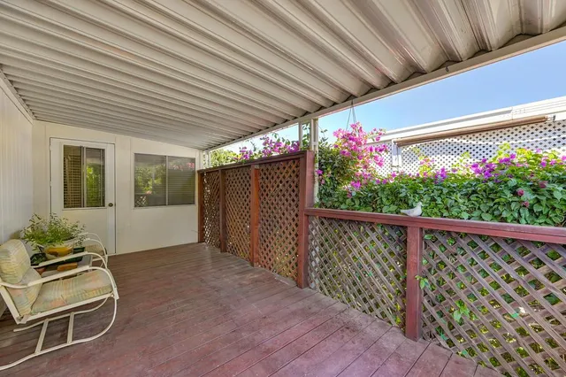 a backyard of a house with wooden fence and flowers