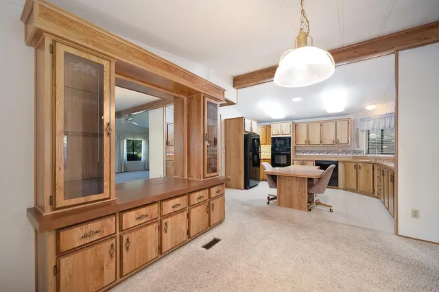 a large white kitchen with a large window and stainless steel appliances
