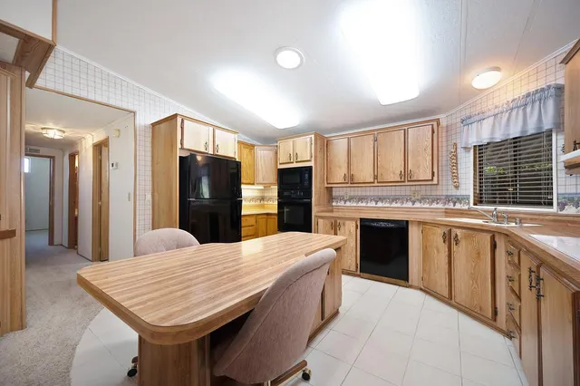 a large kitchen with kitchen island a sink stainless steel appliances and cabinets
