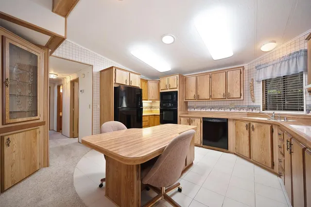 a kitchen with granite countertop kitchen island wooden cabinets a counter top space a sink stainless steel appliances and cabinets