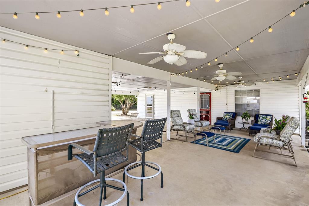 626 Epps Road Palmer, TX 75152 - Photo 38 of 40 Spacious covered patio featuring string lighting, multiple ceiling fans, and a bar area
