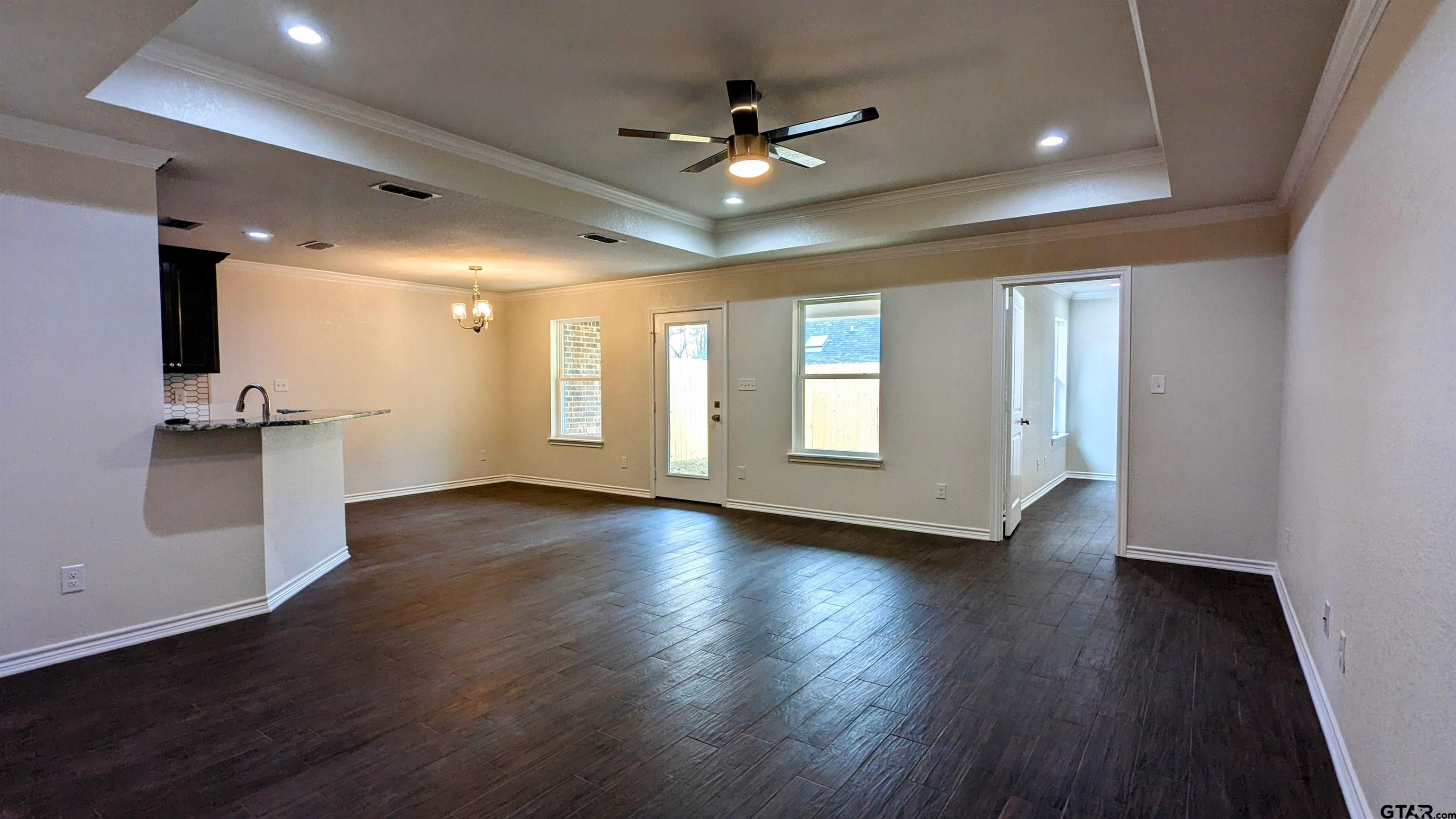 11086 County Road 167, Unit 9 Tyler, TX 75703 - Photo 8 of 20 an empty room with wooden floor and a ceiling fan