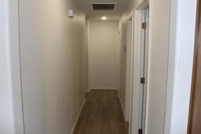 an empty room with wooden floor and a window