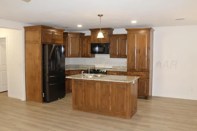 a kitchen with stainless steel appliances granite countertop a refrigerator a sink and a stove