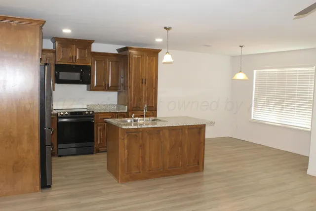 a kitchen with stainless steel appliances granite countertop a stove a sink and a refrigerator