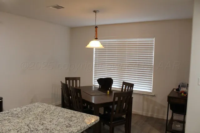 a view of a dining room with a table and chairs