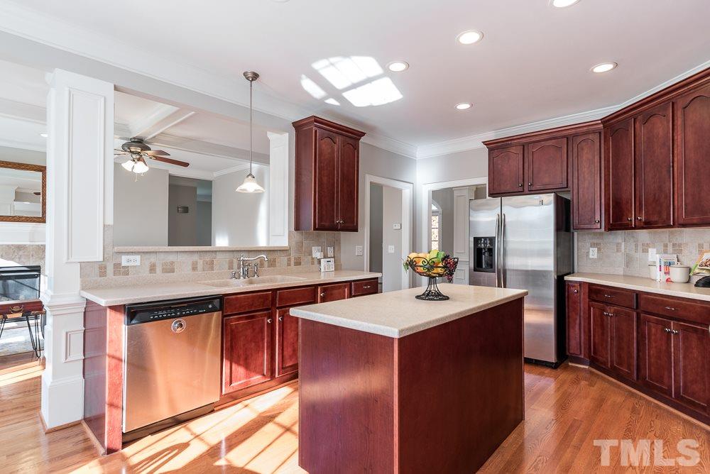 12708 Norwood Road Raleigh, NC 27613 - Photo 7 of 24 a kitchen with a sink a center island cabinets and stainless steel appliances