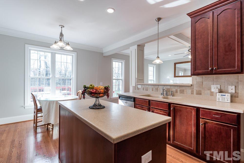 12708 Norwood Road Raleigh, NC 27613 - Photo 8 of 24 a kitchen with a sink a center island cabinets and a window