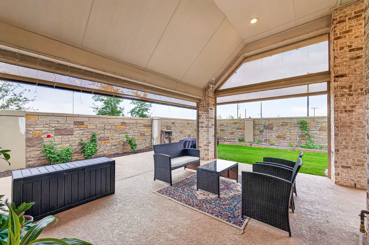 29730 Smoky Ridge Road Fulshear, TX 77441 - Photo 22 of 29 Wrap around extended patio with power shades completely remote controlled adding an entire exterior room space