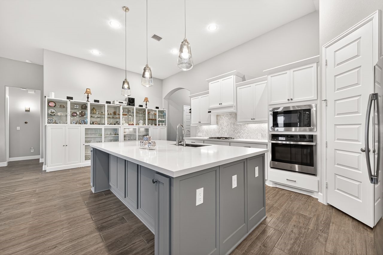 29730 Smoky Ridge Road Fulshear, TX 77441 - Photo 8 of 29 White painted cabinets and off-set island designer color, pendant lighting and walk in pantry
