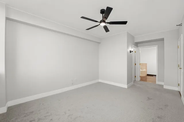 wooden floor in an empty room and a ceiling fan