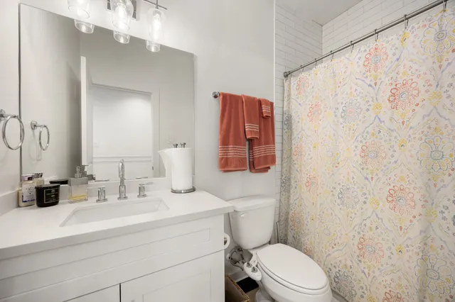 a bathroom with a sink a toilet and shower curtain