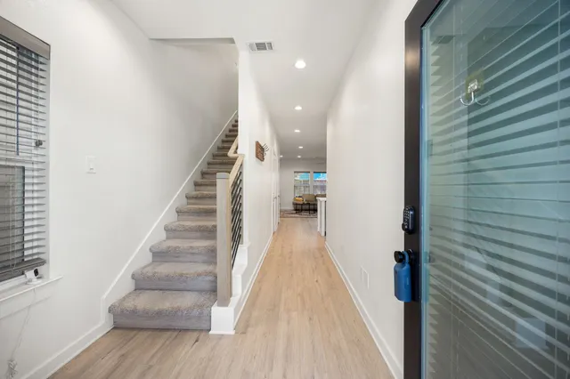 a view of a hallway with wooden floor and staircase