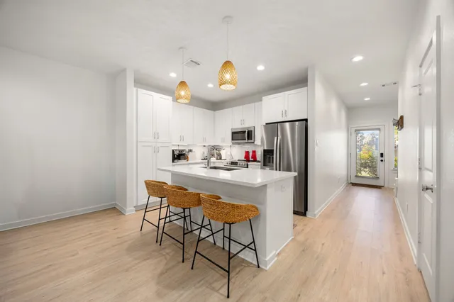 a kitchen with stainless steel appliances kitchen island granite countertop a refrigerator and a stove top oven