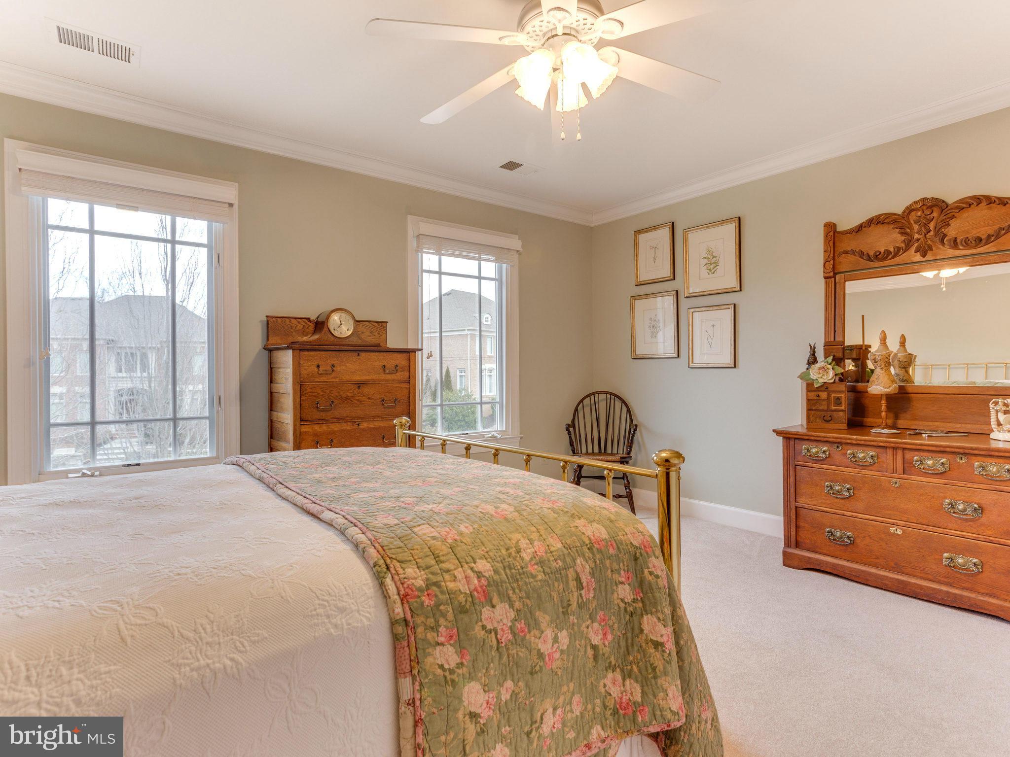 11107 Chessington Place Reston, VA 20194 - Photo 21 of 30 a bedroom with a bed and dresser with mirror