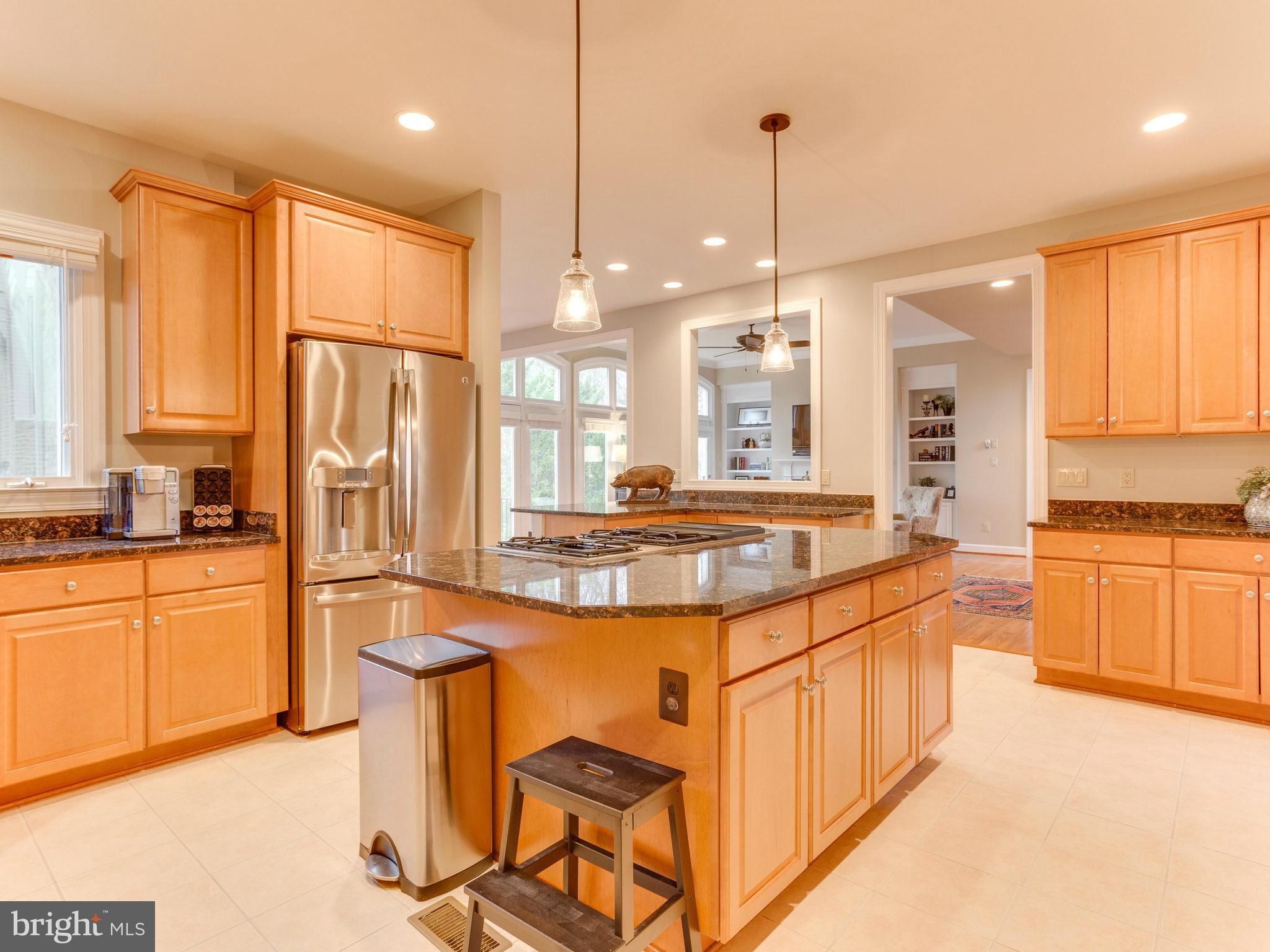 11107 Chessington Place Reston, VA 20194 - Photo 9 of 30 a kitchen with stainless steel appliances granite countertop a stove a sink a refrigerator and white cabinets with wooden floor
